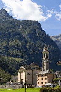 Buildings by mountains against sky