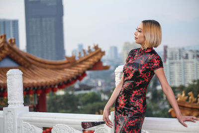 Woman looking away while standing on building terrace