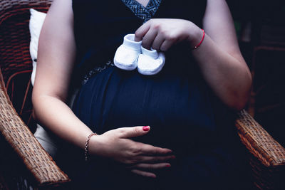 Midsection of woman sitting on chair