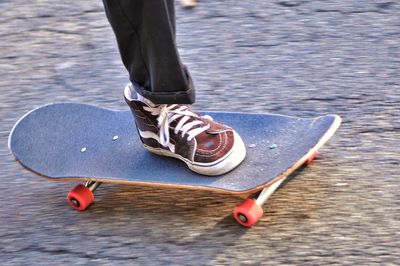 Low section of woman standing on skateboard