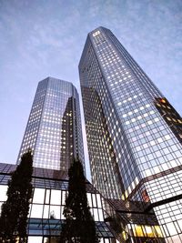 Low angle view of modern skyscraper against blue sky