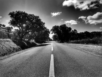 Road amidst trees against sky