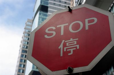 Low angle view of stop sign by buildings in city