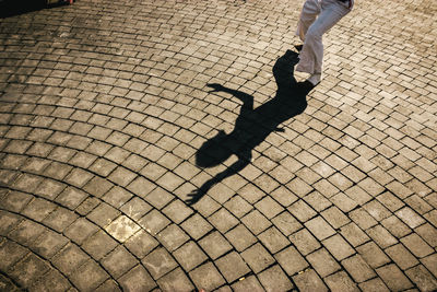 Low section of man walking on cobblestone street