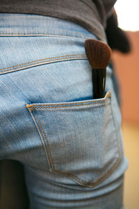 Rear view of woman with make-up brush in pocket