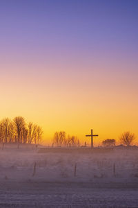 Religious cross at an old church ruin in a beautiful sunset