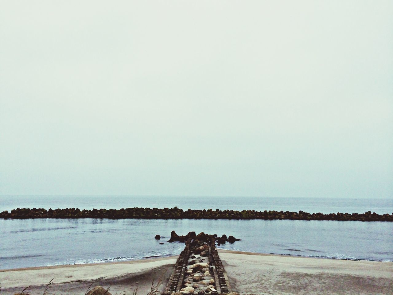 sea, water, beach, clear sky, copy space, horizon over water, shore, tranquility, tranquil scene, sand, scenics, nature, beauty in nature, sky, day, outdoors, pier, built structure, coastline, idyllic