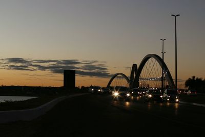 Illuminated bridge against sky at sunset