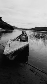 Boat moored in lake against sky