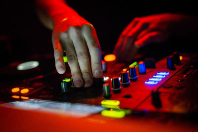 Close-up of hand holding illuminated lighting equipment at night