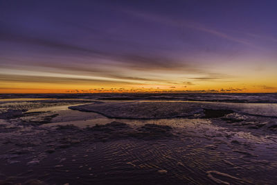 Scenic view of beach against sky during sunset