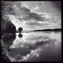 Scenic view of lake against cloudy sky