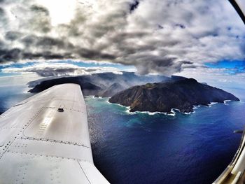 Aerial view of sea and mountains against sky