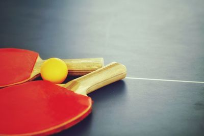 Red table tennis rackets and ball in court