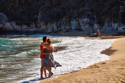 Couple taking selfie at sea shore on sunny day