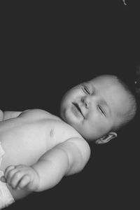 Close-up of baby boy sleeping against black background