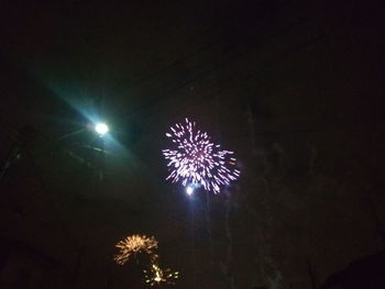 Low angle view of firework display at night