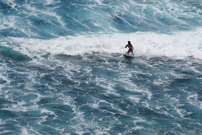 Man surfing in sea against sky