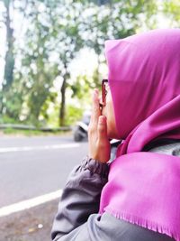 Profile view of woman wearing pink hijab while standing at roadside