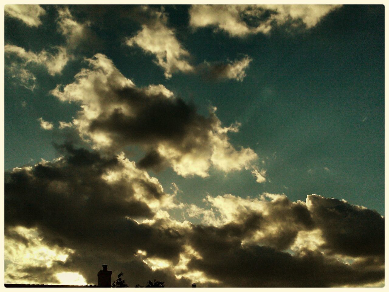 low angle view, sky, transfer print, cloud - sky, cloudy, auto post production filter, cloud, silhouette, beauty in nature, blue, nature, cloudscape, tranquility, scenics, outdoors, high section, sunlight, no people, day, weather