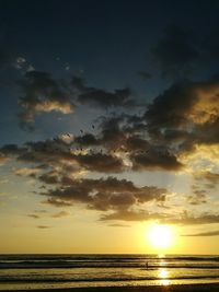 Scenic view of sea against dramatic sky during sunset