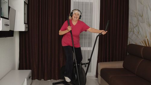 Woman standing on sofa at home