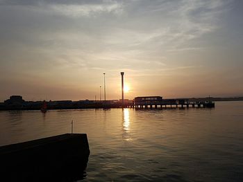 Boats in calm sea at sunset