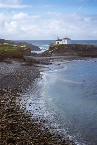 Atlantic ocean. galicia, spain. scenic view of white chapel on top of a rock.virxe do porto ermitage