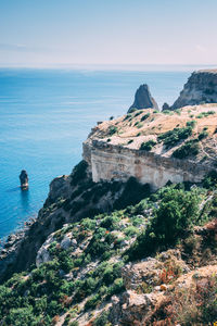 High angle view of sea by mountain against clear sky