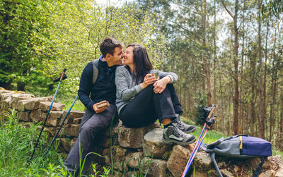 Young couple kissing against plants