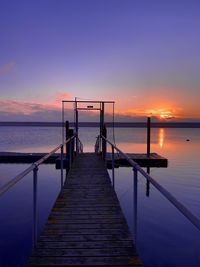 Pier on sea against sky during sunset