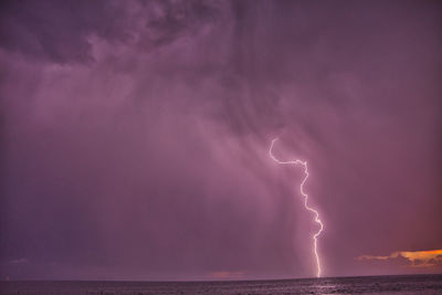 Panoramic view of lightning over sea against sky