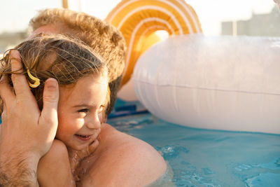 Father and daughter having fun in swimming pool 