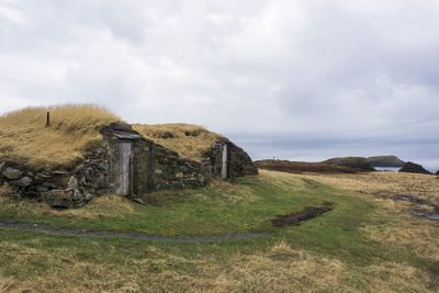 Built structure on field against sky