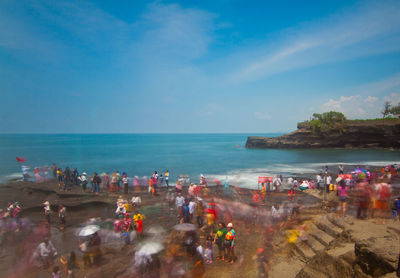 People at beach against sky