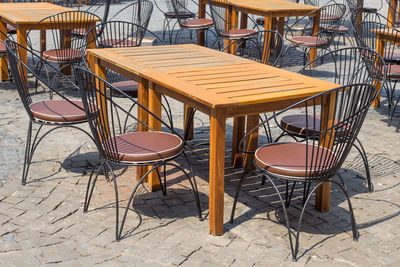 High angle view of empty chairs and table at sidewalk cafe
