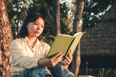 Young woman sitting on book