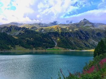 Scenic view of lake by mountains against sky