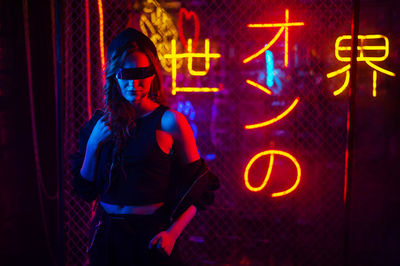 Portrait of woman standing against graffiti wall