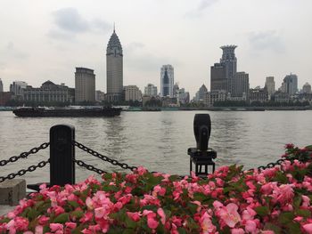 Scenic view of river by buildings against sky