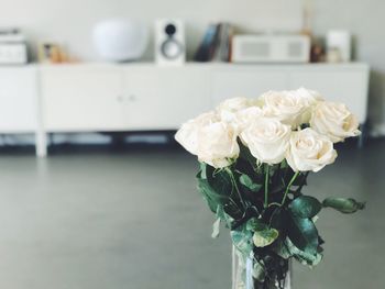 Close-up of white roses in vase on table