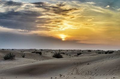 Scenic view of desert against sky during sunset