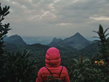 Woman in red jacket against mountains