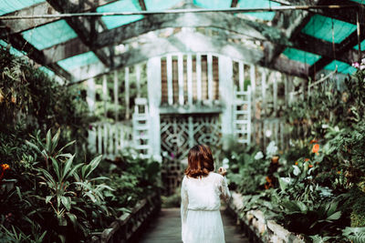 Rear view of woman standing by plants