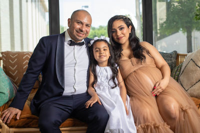 Portrait of smiling family sitting on sofa 