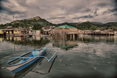 Houses by lake against sky