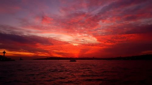 Scenic view of sea against dramatic sky during sunset