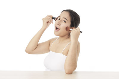 Young woman looking away against white background