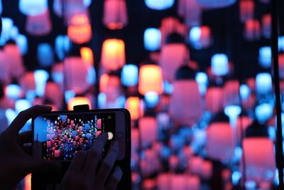 People photographing illuminated smart phone at music concert