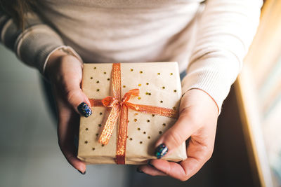 Midsection of woman holding christmas present